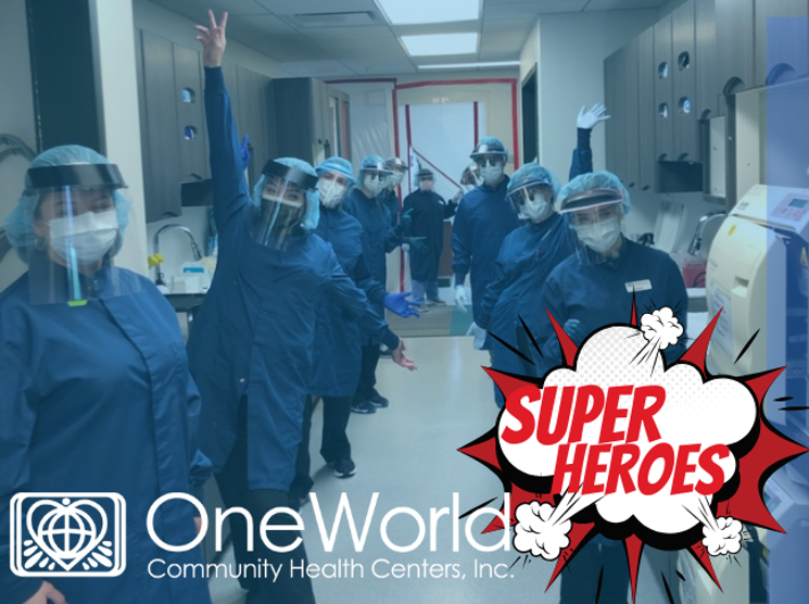 OneWorld providers with protective coverings standing in a group cheering